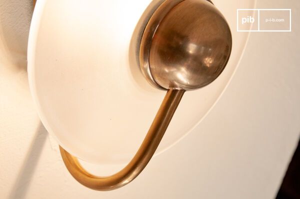 La structure en laiton vieilli met en valeur un disque de verre dépoli qui diffuse une lumière douce.