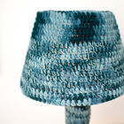 De lamp is volledig bedekt met handgehaakt textiel.