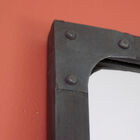 Detail van het metalen frame op een oranje achtergrond.