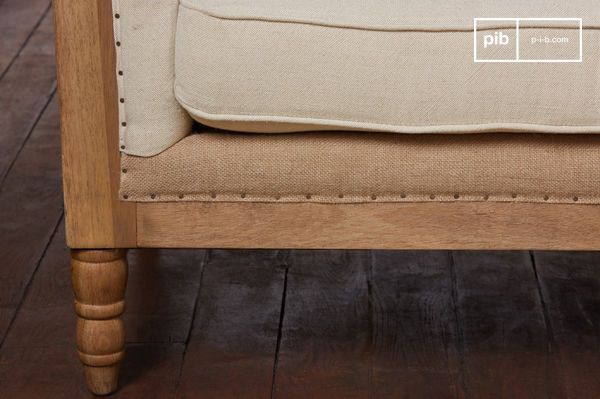 Les détails de tapisserie, coutures apparentes, piquages, clous, sont assumés comme partie intégrante du design. Les pieds tournés renforcent cette filiation traditionnelle.