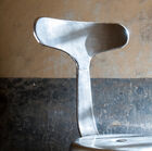 The chair is entirely made of patinated grey metal.