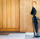 A vintage umbrella holder in black wrought iron.