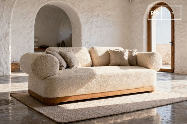 Texture bouclée et socle en chêne pour une assise enveloppante.