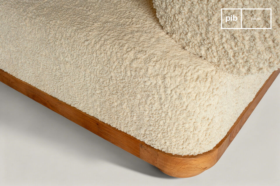 Ce canapé affiche une présence sereine par ses volumes généreux et sa texture bouclée