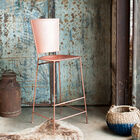 Le tabouret est d'une belle couleur cuivré qui tend vers un joli rose.