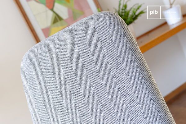 Le dossier haut est tapissé de tissu à chevron gris chiné résistant et facile à vivre.