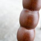 One of the legs is all roundness carved in the wood.