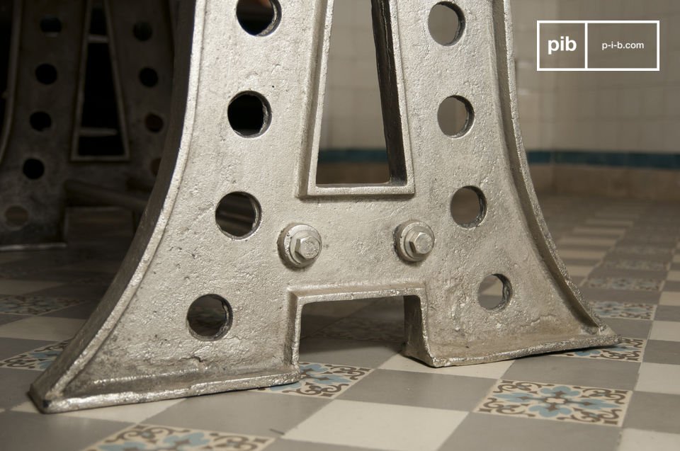 una base de acero estilo Eiffel cuidadosamente patinada.