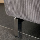 De bank eindigt met een elegante metalen voet.