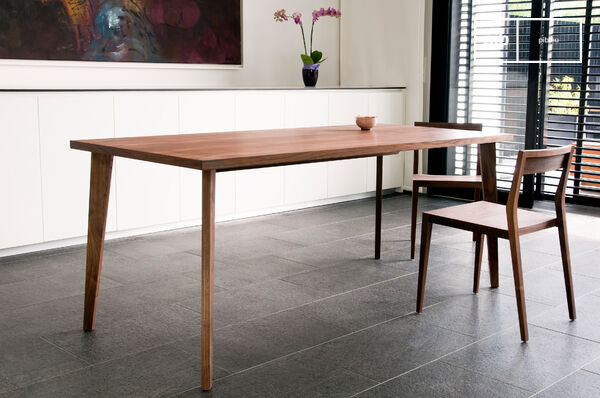 Der Tisch aus Nussbaum ist vom skandinavischen Design inspiriert.