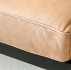 Le cuir marron clair du fauteuil et sa jolie surpiqûre de la même couleur.