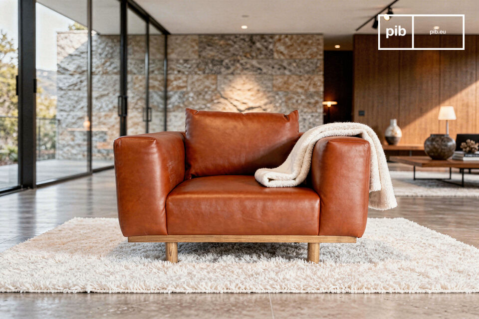 Ce large fauteuil repose sur une structure apparente en chêne massif