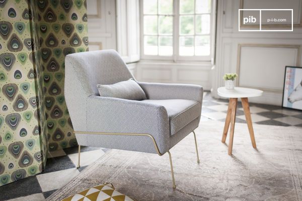 Un fauteuil aux lignes sobres de style mid-century revisité, associant textile graphique et piètement filaire doré.