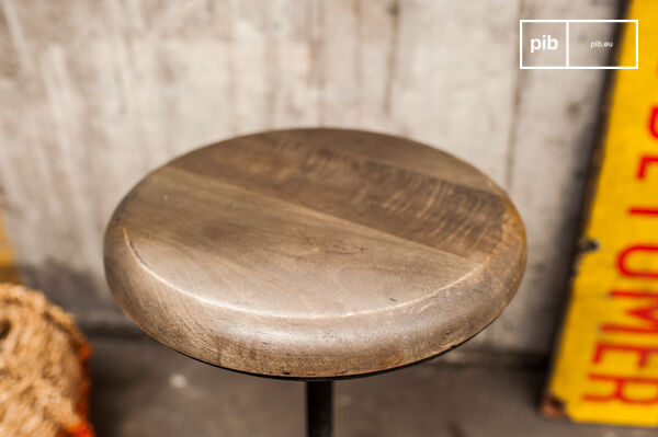 The round seat is made of wood, which tends towards grey.
