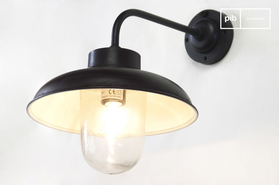 Contrast van het donkere matte van de wandlamp op de openhartigheid van de muur.