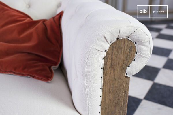 Le rouleau capitonné se termine par une joue boisée apparente ponctuée de clous de tapissier.