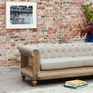 Le dossier et les accoudoirs alignés composent un volume enveloppant typique du Chesterfield.