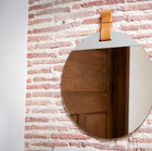 Beau mirroir rond maintenu par une languette.