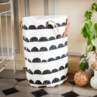Beautiful white laundry basket with black patterns.