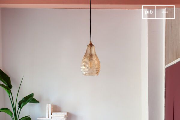 Mit ihrem dezent orange getönten Glas und den Messingdetails zieht die Hängelampe Abaca mit ihrem
