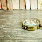 Nice compass on varnished wooden desk.