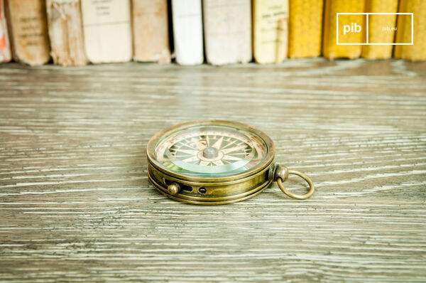 Nice compass on varnished wooden desk.
