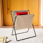 Beige tijdschriftenhouder met zwarte metalen structuur.