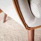 The dark solid wood base contrasts with the light fabric.