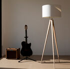 Large tripod floor lamp with white lampshade.
