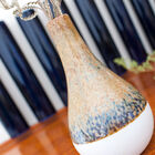 Die Vase hat blaue Flecken und ein braunes Finish.