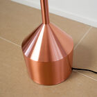 Le lampadaire en métal est recouvert d'une couche de cuivre rosé.
