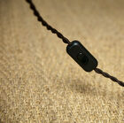 Bonito cordón eléctrico rodeado de una trenza textil marrón.