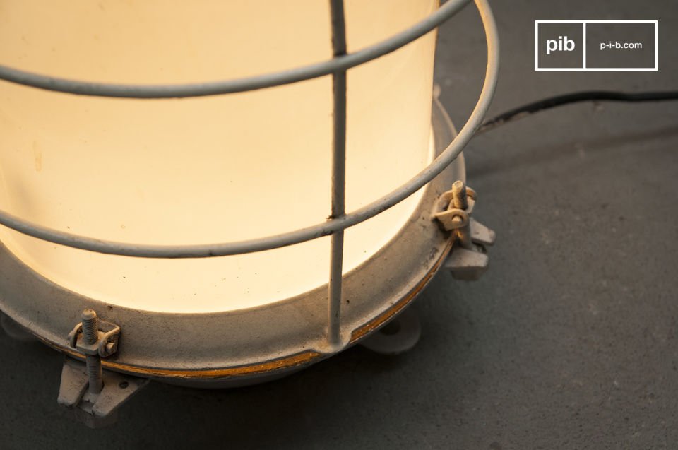La lampe dispose d'une structure grillagée métallique blanche.
