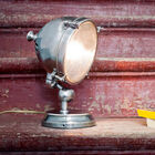 La lampe adopte une forme de projecteur rappelant les phares d'automobiles.