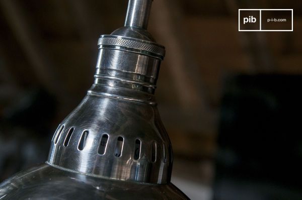 Une série de fentes de ventilation confirme la référence aux lampes techniques du milieu du XXe siècle.