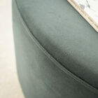 The art deco charm of a pouf combining golden brass and soft velvet