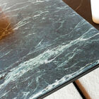 The black structure blends with the deep, ribbed green of the marble.