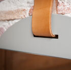 The mirror is suspended by a thick strip of light leather.