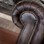 The arms of this sofa are upholstered in studded leather