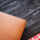 The light leather of the cushions contrasts perfectly with the dark wood.