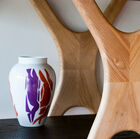 Its light wood structure consists of inverted brackets under which the shelves hang