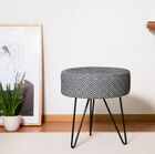 Ethnischer Hocker mit elegantem, abgerundetem Metallfuß.