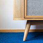 With its light oak veneer structure and solid wood legs