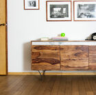 Groot dressoir op kleine zwart metalen poten.