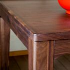 La mesa tiene un sublime color madera oscura.