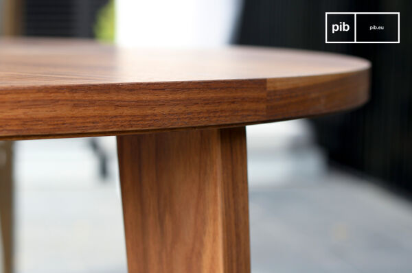 Esta mesa de nogal redonda con sus finas líneas armoniosas está inspirada en el diseño