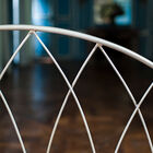 De rugleuning is een dunne geometrische metalen structuur.