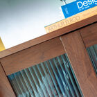 Les portes coulissantes en bois et verre cannelé laissent entrevoir les objets.