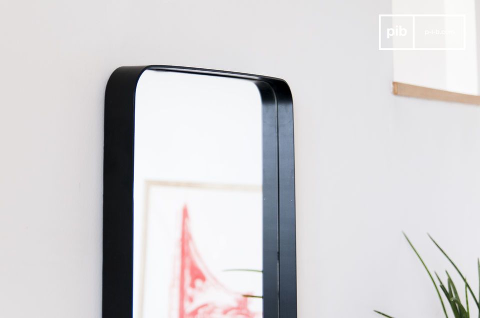 Une fine lame de métal noir souligne la forme géométrique du miroir.