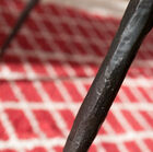 Its three black metal feet, hammered by hand, give this side table a graceful and light aspect